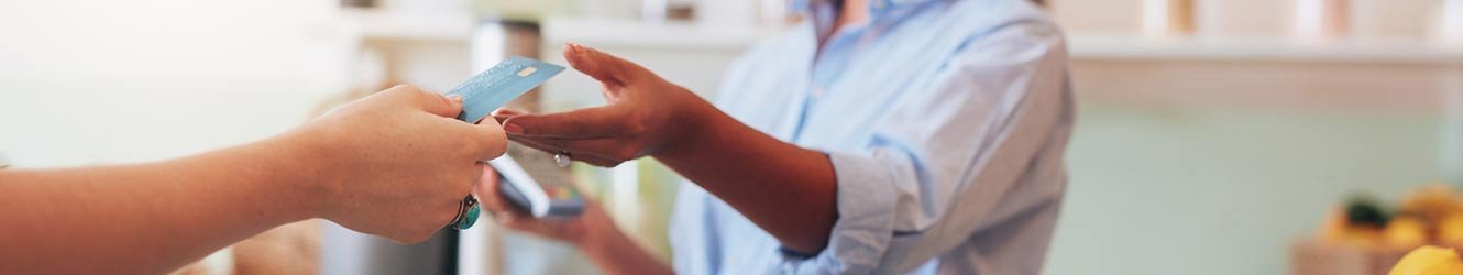 Person handing over debit card to cashier.